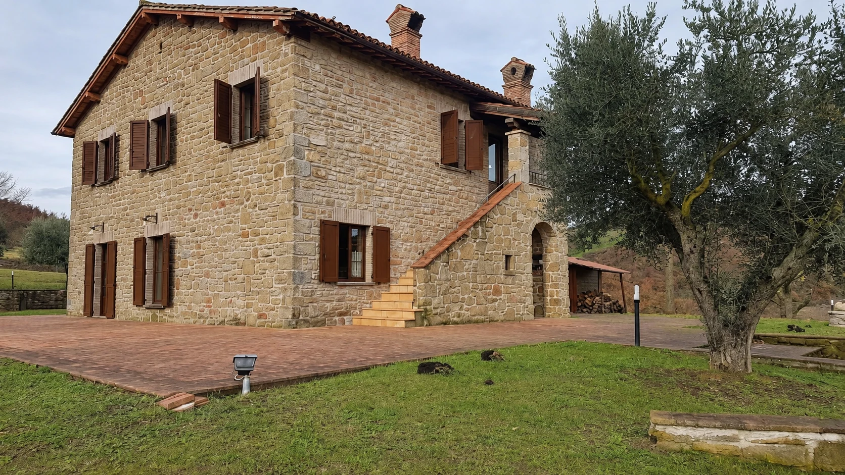 Il casale in pietra, con scala esterna e ulivo