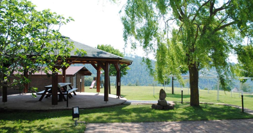 Il gazebo in legno con grande tavolo, circondato dal prato